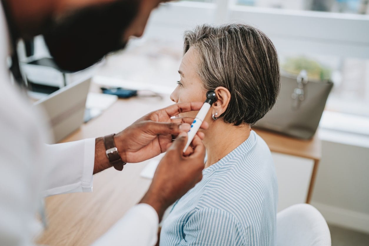 Doctor examining a patient's ear with an otoscope